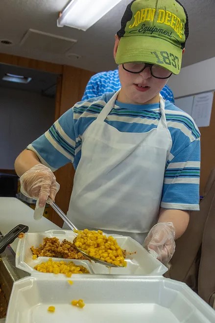 Collin Mina Serving Lunch inside Gus the Bus